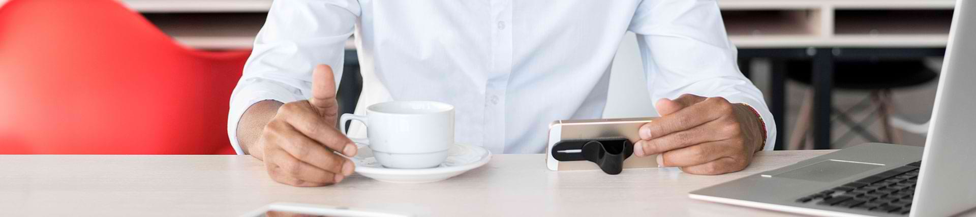 Man drinking coffee in front of a laptop